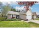 A well-maintained suburban home features a blend of brick and siding with a two-car garage and lush landscaping at 6853 Arjay Dr, Indianapolis, IN 46217