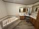 Bathroom featuring laminate flooring, neutral paint, wood trim, double sink and a bathtub at 7765 N 225 W, Lebanon, IN 46052