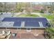 Brick home featuring solar panels, concrete patio, lush backyard, and mature trees at 8051 Sycamore Springs Trl, Indianapolis, IN 46239