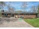 Brick home featuring a concrete patio and outdoor seating with lush greenery and solar panels at 8051 Sycamore Springs Trl, Indianapolis, IN 46239