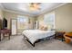 A cozy bedroom bathed in natural light, featuring a ceiling fan, simple furnishings, and inviting decor at 8051 Sycamore Springs Trl, Indianapolis, IN 46239
