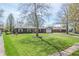Charming brick ranch home with mature landscaping, large front yard, and attached garage at 8051 Sycamore Springs Trl, Indianapolis, IN 46239