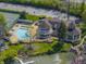 Stunning aerial view of a luxurious waterfront estate featuring a pool, tennis court, and manicured gardens at 8069 Middle Bay Ln, Indianapolis, IN 46236