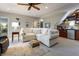Inviting basement features a comfortable sectional, wet bar with stone backsplash, and ample lighting at 8069 Middle Bay Ln, Indianapolis, IN 46236