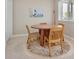 Cozy dining area features a round wooden table, four chairs, and a sunlit window with a pleasant view at 8069 Middle Bay Ln, Indianapolis, IN 46236