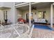 Charming covered patio with stone floors, ceiling fan and seating area perfect for entertaining at 8069 Middle Bay Ln, Indianapolis, IN 46236