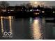 Night view of a waterfront featuring illuminated houses and reflections on the calm water at 8069 Middle Bay Ln, Indianapolis, IN 46236