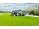 Aerial view of a house with a large lawn, mature trees, and a long driveway at 8850 W 225 S, Columbus, IN 47201