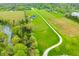 Aerial view of the property with a pond, trees, home and long driveway at 8850 W 225 S, Columbus, IN 47201