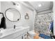 Modern bathroom features white vanity, black fixtures, round mirror, and playful dog shower curtain at 8850 W 225 S, Columbus, IN 47201