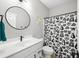 Well-lit bathroom with modern fixtures, decorative mirror, and a whimsical shower curtain at 8850 W 225 S, Columbus, IN 47201