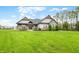 Beautifully landscaped home with stone accents and a lush green lawn in a wooded area at 8850 W 225 S, Columbus, IN 47201