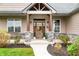 Inviting front porch with stone pillars and wood accents, featuring a swing and seasonal decor at 8850 W 225 S, Columbus, IN 47201