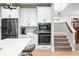 Open concept kitchen with stainless steel appliances, white cabinetry, and stairway access at 8850 W 225 S, Columbus, IN 47201