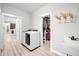 Well-lit laundry room featuring modern appliances, storage solutions, and easy access to a walk-in closet at 8850 W 225 S, Columbus, IN 47201