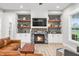 Inviting living room features a stone fireplace, built-in shelves, and a comfortable leather couch at 8850 W 225 S, Columbus, IN 47201