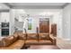 Open-concept living room showcases a staircase, a stylish chandelier, and a beautiful wood front door at 8850 W 225 S, Columbus, IN 47201