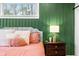 Close-up of a well lit bedroom featuring bedside tables, a green accent wall, and a cozy bed at 8850 W 225 S, Columbus, IN 47201