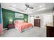 Spacious bedroom featuring a ceiling fan, a green accent wall, and access to the ensuite bathroom at 8850 W 225 S, Columbus, IN 47201