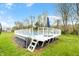 Above-ground pool on a white deck with surrounding lush green landscaping at 8850 W 225 S, Columbus, IN 47201