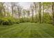 Well-maintained backyard with lush green grass and a tranquil wooded backdrop at 8901 Shetland Ln, Indianapolis, IN 46278