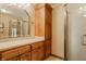 Spacious bathroom with wood cabinets, a large mirror, and glass-enclosed shower at 8901 Shetland Ln, Indianapolis, IN 46278