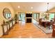 Open-concept dining area with hardwood floors, a stylish chandelier, and views of the living room beyond at 8901 Shetland Ln, Indianapolis, IN 46278