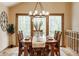 The dining room features a decorative chandelier and views of the home's wooded lot at 8901 Shetland Ln, Indianapolis, IN 46278