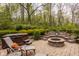 Outdoor fire pit and patio seating area with lush landscaping and natural surroundings at 8901 Shetland Ln, Indianapolis, IN 46278