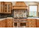 Gourmet kitchen features a Wolf range, custom cabinetry and beautiful granite countertops and backsplash at 8901 Shetland Ln, Indianapolis, IN 46278
