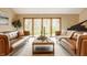 Bright living room with leather sofas, large windows, and natural light, perfect for entertaining at 8901 Shetland Ln, Indianapolis, IN 46278