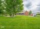 Sprawling backyard with large shed, mature trees, and relaxing seating area at 9243 Compton Farm Ln, Indianapolis, IN 46259