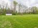 Expansive backyard with lush lawn, a shed, and mature trees offering a serene and private outdoor space at 9243 Compton Farm Ln, Indianapolis, IN 46259