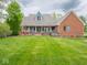 Large backyard featuring a spacious deck, hot tub, and lush green lawn at 9243 Compton Farm Ln, Indianapolis, IN 46259