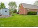 Spacious backyard featuring a lawn, shed, and brick home at 9243 Compton Farm Ln, Indianapolis, IN 46259
