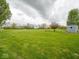 Expansive backyard with lush green grass and mature trees at 9243 Compton Farm Ln, Indianapolis, IN 46259