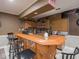 Basement bar features light wood cabinets, sports-themed decor, and a large wooden countertop for seating at 9243 Compton Farm Ln, Indianapolis, IN 46259