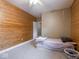 Cozy bedroom featuring wood paneling, carpet and ceiling fan at 9243 Compton Farm Ln, Indianapolis, IN 46259