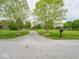 Long driveway leading to a home with a well-manicured lawn and mature trees at 9243 Compton Farm Ln, Indianapolis, IN 46259