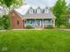 Charming blue home boasts a welcoming front porch, manicured lawn, and classic architectural details for curb appeal at 9243 Compton Farm Ln, Indianapolis, IN 46259