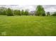 Well-manicured front yard with a beautiful lawn, trees, and a charming home at 9243 Compton Farm Ln, Indianapolis, IN 46259