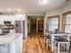 Eat-in kitchen view featuring stainless appliances, wood floors, island and a table with seating at 9243 Compton Farm Ln, Indianapolis, IN 46259