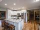 Bright kitchen features an island with granite countertops, stainless steel appliances, and wood floors at 9243 Compton Farm Ln, Indianapolis, IN 46259