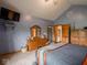 A spacious main bedroom with blue walls, wooden furniture, and a TV at 9243 Compton Farm Ln, Indianapolis, IN 46259