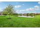 Picturesque view of a community pond with mature trees and grass leading to the water at 963 Kempson Ct, Westfield, IN 46074