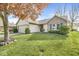 Well-manicured lawn and landscape featuring green shutters on a quaint brick and vinyl home exterior at 9688 Amber Glow Ct, Fishers, IN 46037