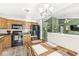 Kitchen featuring wood cabinets, black appliances, and eat-in dining space with a view to the living area at 9688 Amber Glow Ct, Fishers, IN 46037
