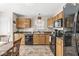 Bright kitchen featuring warm wood cabinets, black appliances, and a functional layout at 9688 Amber Glow Ct, Fishers, IN 46037