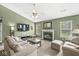 Spacious living room features a decorative fireplace, TV, neutral couches, and an ottoman at 9688 Amber Glow Ct, Fishers, IN 46037