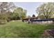Spacious backyard with in-ground pool, lush lawn, mature trees and patio at 1000 Riverview Dr, Martinsville, IN 46151